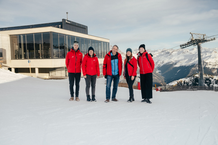 Eine Gruppe von Personen in roten Skijacken im Skiegebiet an der Valisera Bahn Bergstation. | © Montafon Tourismus - Marie Rudigier