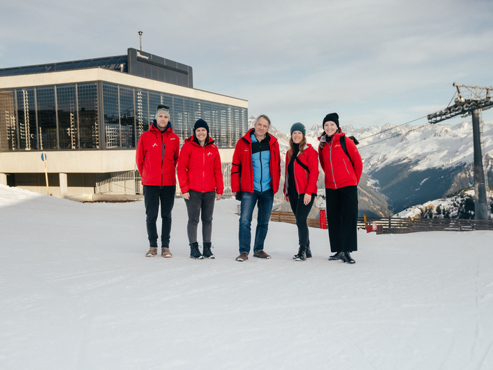 Eine Gruppe von Personen in roten Skijacken im Skiegebiet an der Valisera Bahn Bergstation. | © Montafon Tourismus - Marie Rudigier