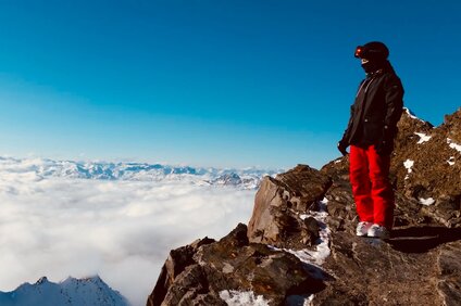 Eine Frau steht in Skiausrüstung auf einem Felsen im Skigebiet Silvretta Montafon. | © Luisa Idler - Silvretta Montafon