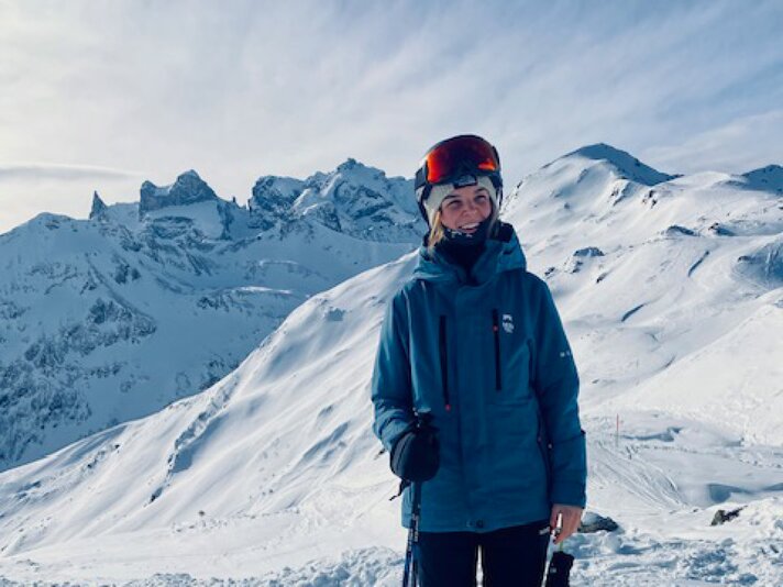 Ein Mädchen steht in Skikleidung vor einer verschneiten Bergkulisse. | © Luisa Idler - Silvretta Montafon