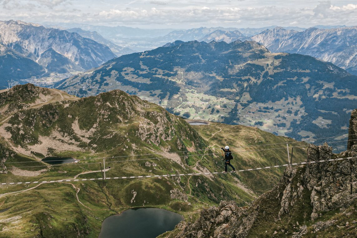 Eine Person läuft über Hochseilbrücke im Klettersteig in der Silvretta Montafon | © Silvretta Montafon
