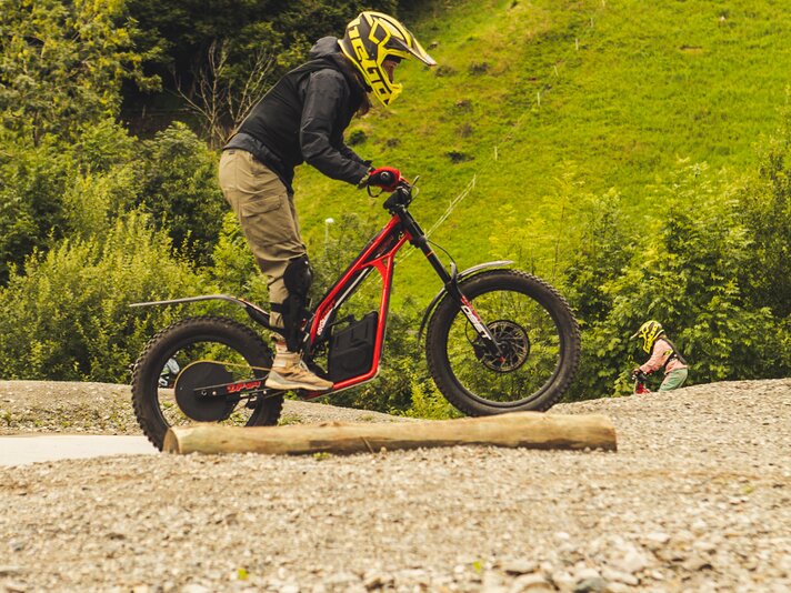 Eine Person mit Schutzausrüstung fährt auf dem Pacour mit einem elektronischen Trail-Bike. | © Silvretta Montafon - Roadtyping