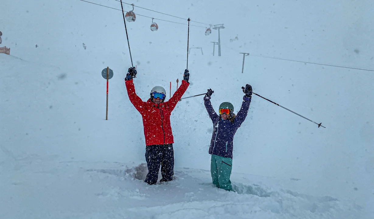 Zwei Personen stehen jubelnd im Tiefschnee im Skigebiet Silvretta Montafon. | © Silvretta Montafon