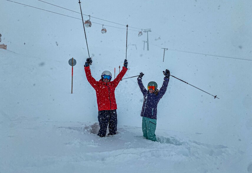 Zwei Personen stehen jubelnd im Tiefschnee im Skigebiet Silvretta Montafon. | © Silvretta Montafon