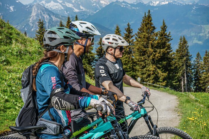 Drei Mountainbiker mit Bike stehen in den Bergen und genießen die Aussicht in der Silvretta Montafon. | © Silvretta Montafon - Vanessa Strauch