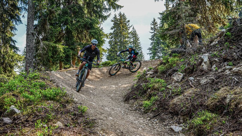 Zwei Biker fahren in einer Kurve durch den Bikepark am Hochjoch in der Silvretta Montafon. | © Silvretta Montafon - Vanessa Strauch