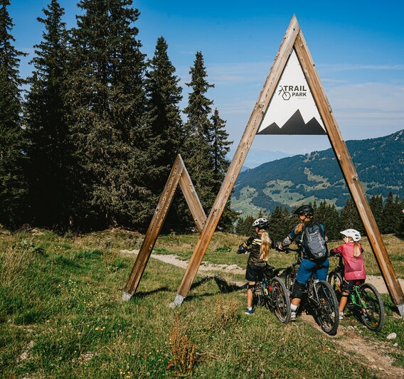 Eine Familie mit einer Frau und zwei Kindern am Eintrittsportal zum Trailpark am Hochjoch in der Silvretta Montafon.  | © Silvretta Montafon - Vanessa Strauch