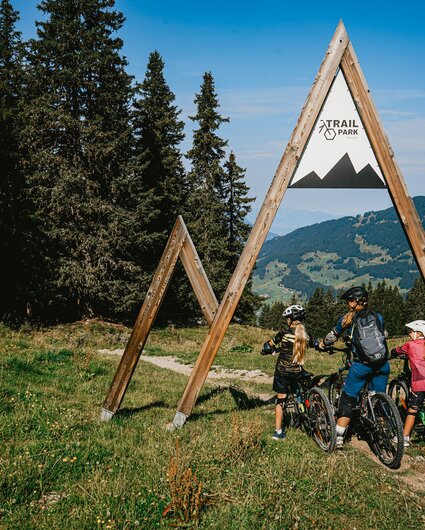 Eine Familie mit einer Frau und zwei Kindern am Eintrittsportal zum Trailpark am Hochjoch in der Silvretta Montafon.  | © Silvretta Montafon - Vanessa Strauch
