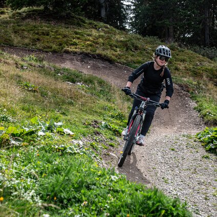 Ein Mädchen fährt mit einem Mountainbike auf dem Trailpark am Hochjoch. | © Silvretta Montafon - Frederike Weber