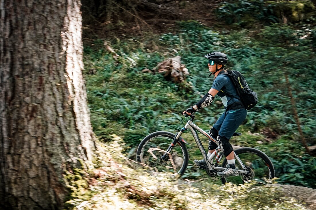 Eine Frau fährt auf einem Biketrail im Wald am Hochjoch in der Silvretta Montafon. | © Silvretta Montafon - Vanessa Strauch