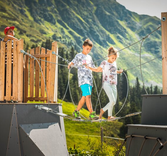 Zwei Kinder auf einem Kletterseil im Aktivrevier am Abenteuerberg Hochjoch in der Silvretta Montafon. | © Silvretta Montafon - Stefan Kothner