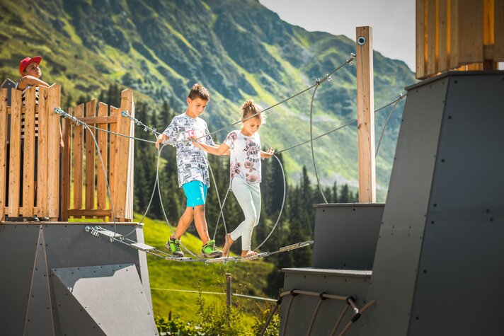 Zwei Kinder auf einem Kletterseil im Aktivrevier am Abenteuerberg Hochjoch in der Silvretta Montafon. | © Silvretta Montafon - Stefan Kothner