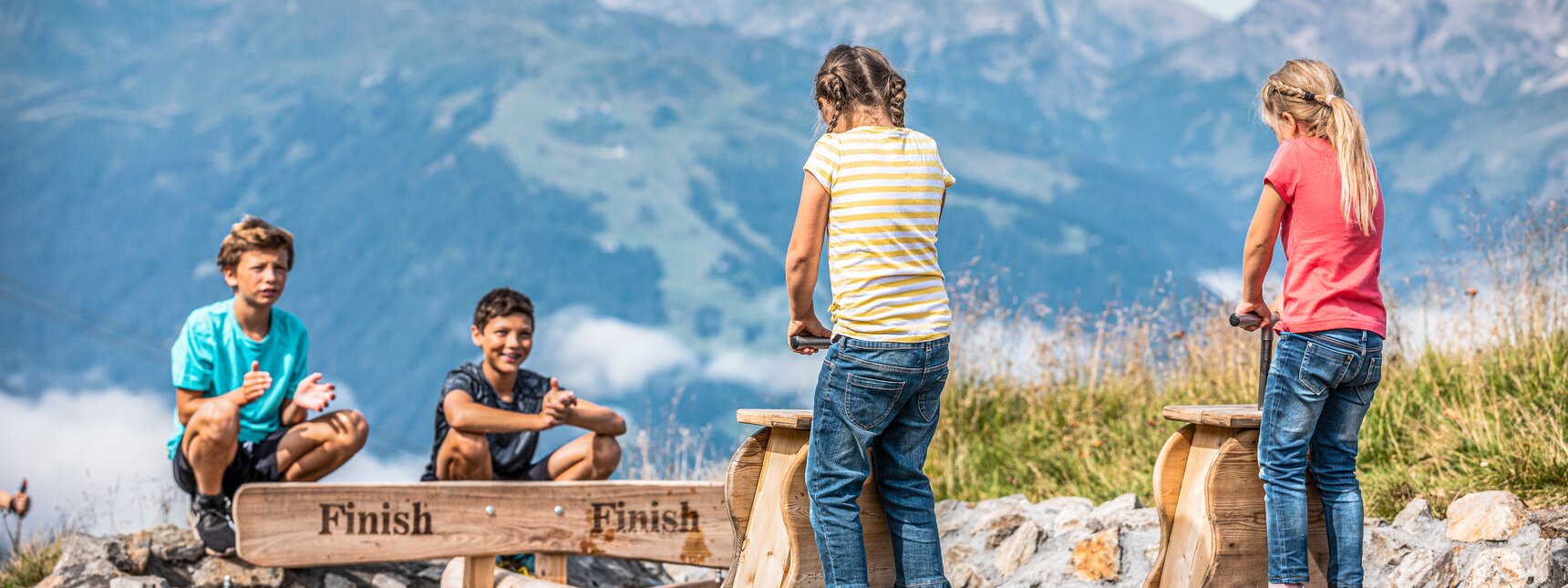 Vier Kinder an den Wellenpumpen am Naturkräftepfad am Erlebnisberg Hochjoch in der Silvretta Montafon. | © Silvretta Montafon - Stefan Kothner