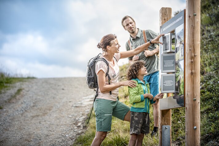 Eine Familie steht an einer Station am Themenweg Vier Barga in der Silvretta Montafon.  | © Silvretta Montafon - Stefan Kothner