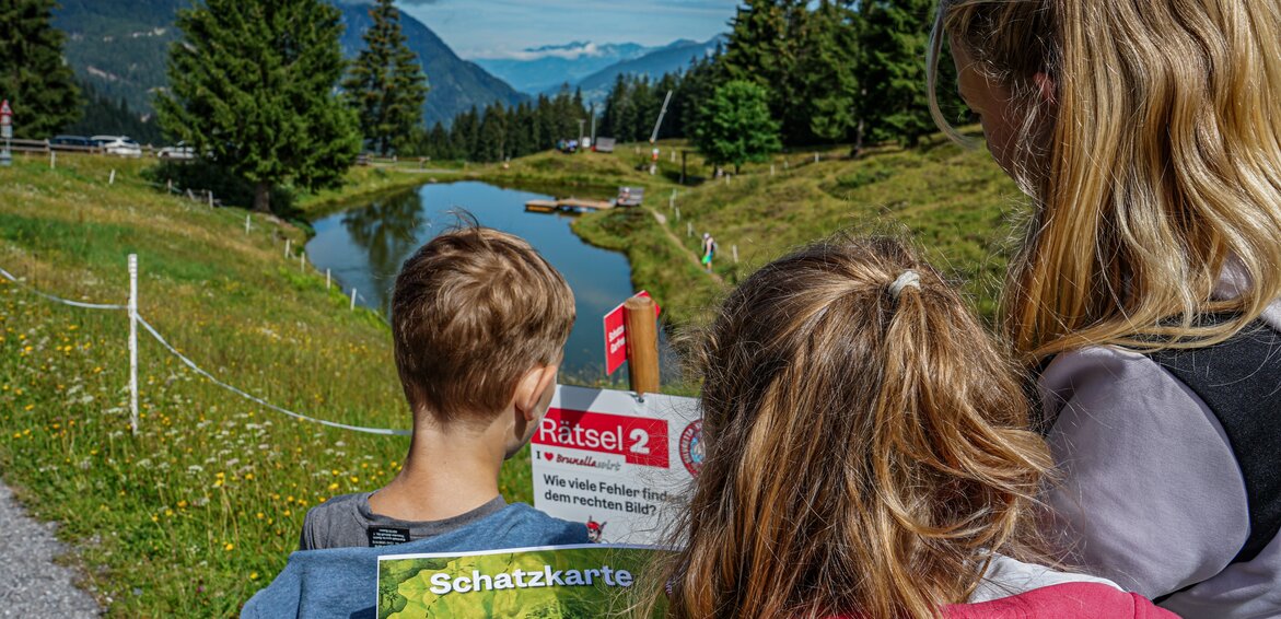 Station bei der Schatzsuche Garfrescha - Silvretta Montafon | © Silvretta Montafon - Vanessa Strauch Kinder stehen bei einer Station bei der Schatzsuche Garfrescha in der Silvretta Montafon. | © Silvretta Montafon - Vanessa Strauch