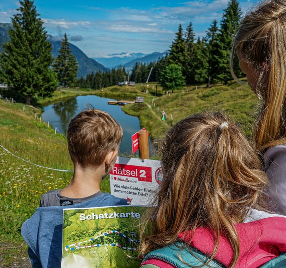 Kinder stehen bei einer Station bei der Schatzsuche Garfrescha in der Silvretta Montafon. | © Silvretta Montafon - Vanessa Strauch
