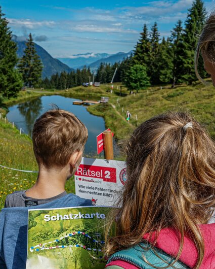 Kinder stehen bei einer Station bei der Schatzsuche Garfrescha in der Silvretta Montafon. | © Silvretta Montafon - Vanessa Strauch