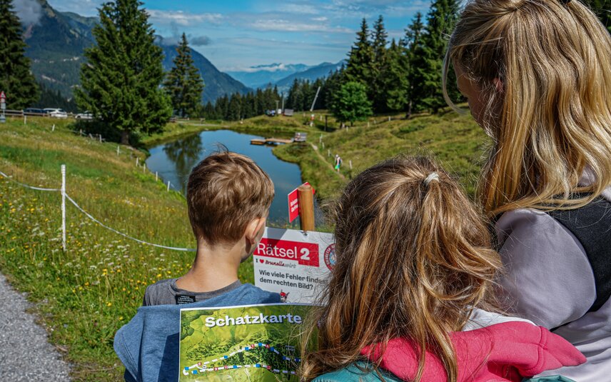 Kinder stehen bei einer Station bei der Schatzsuche Garfrescha in der Silvretta Montafon. | © Silvretta Montafon - Vanessa Strauch