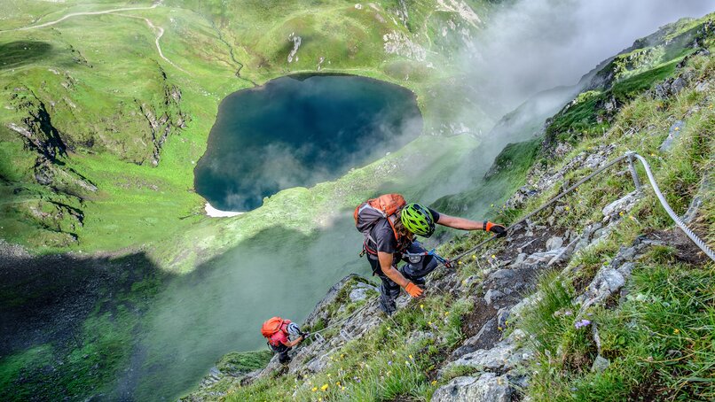 Zwei Personen im Klettersteig oberhalb eines Bergsees in der Silvretta Montafon. | © Silvretta Montafon - Bertram Waldner