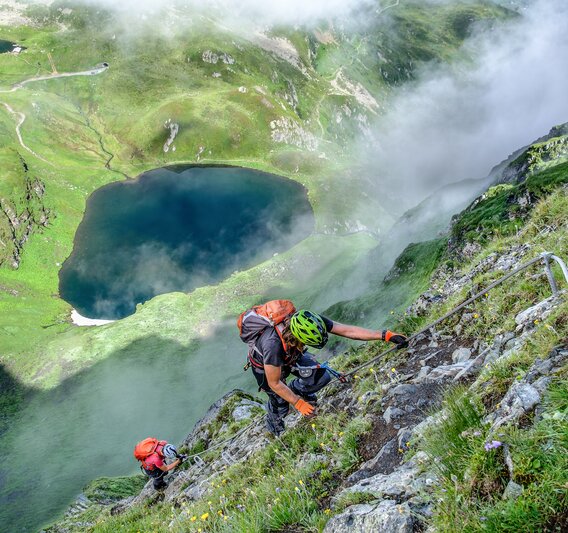 Zwei Personen im Klettersteig oberhalb eines Bergsees in der Silvretta Montafon. | © Silvretta Montafon - Bertram Waldner