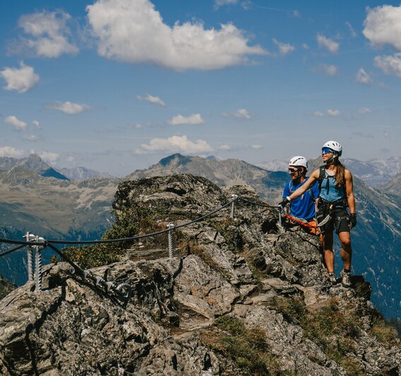 Eine Frau und ein Mann genießen die Aussicht am Klettersteig Madrisella. | © Silvretta Montafon - Vanessa Strauch