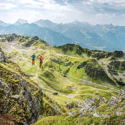 Zwei Kletterer laufen über die Seilbrücke am Klettersteig Hochjoch in der Silvretta Montafon. | © Silvretta Montafon - Stefan Kothner