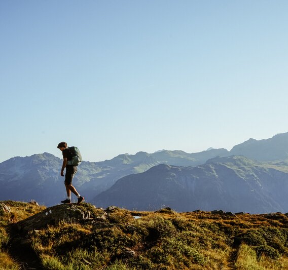 Ein Mannwandern am Grat in den Bergen mit Aussicht über die umliegenden Gipfel. | © Silvretta Montafon - Vanessa Strauch