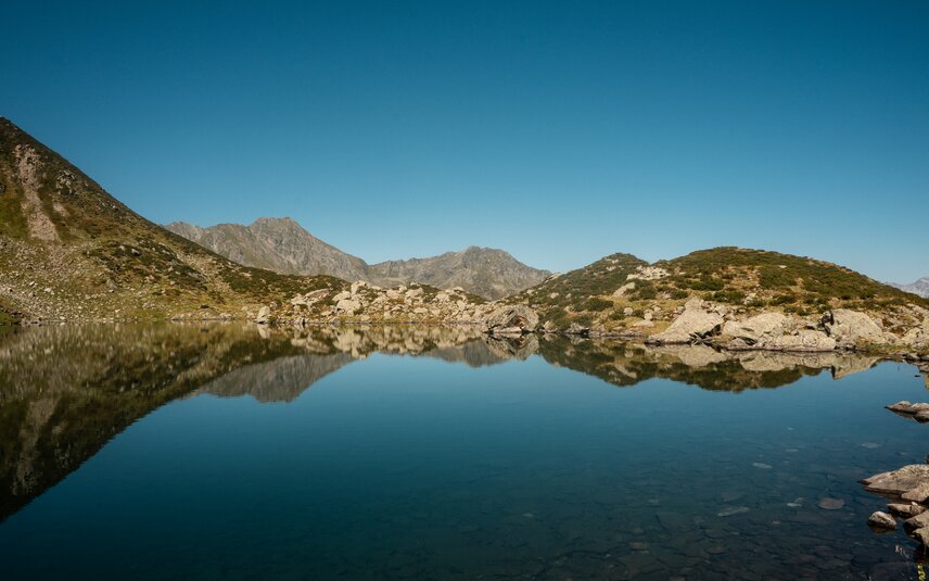 Der Alpgues See mit reflektierenden Bergen in der Silvretta Montafon. | © Silvretta Montafon - Vanessa Strauch
