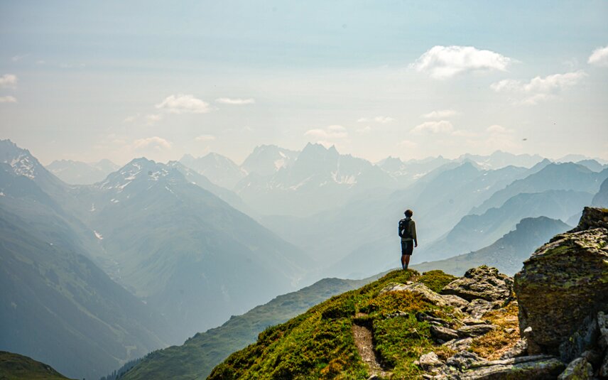 Ein Wanderer steht am Panoramaweg Zamang und genießt die Aussicht beim Wandern in der Silvretta Montafon. | © Silvretta Montafon - Vanessa Strauch