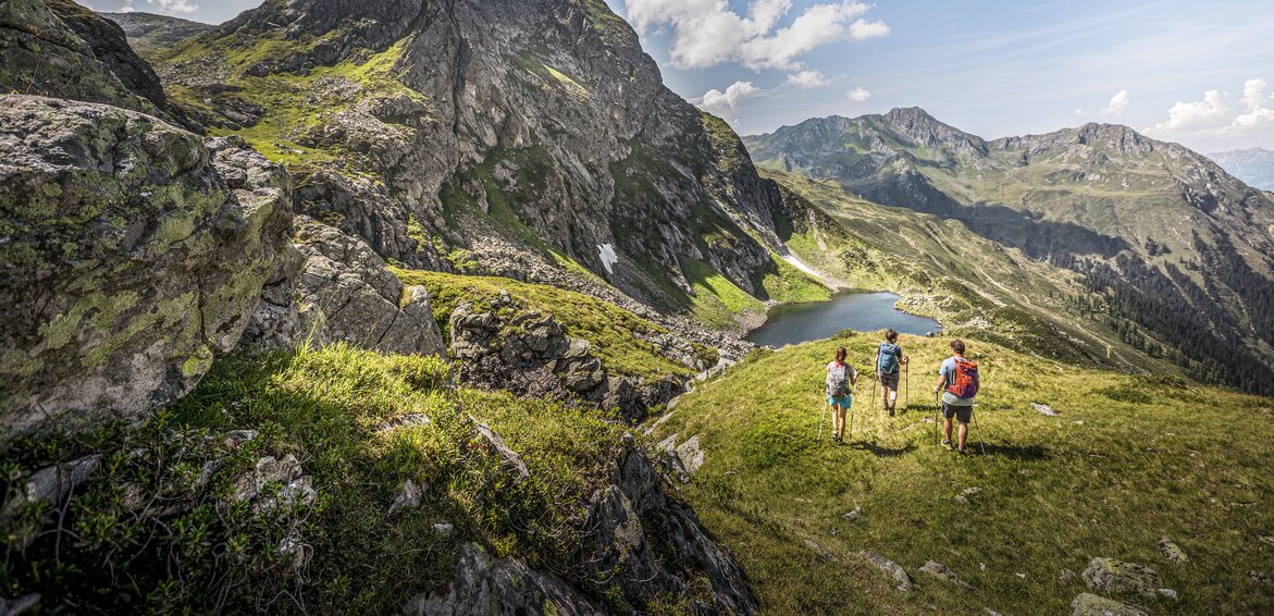 Drei Personen wandern Richtung Herzsee im Sommer am Hochjoch in der Silvretta Montafon. | © Silvretta Montafon - Stefan Kothner