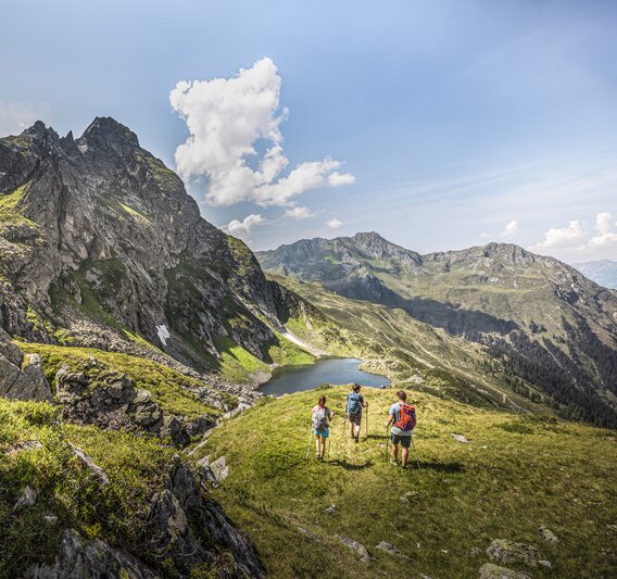 Drei Personen wandern Richtung Herzsee im Sommer am Hochjoch in der Silvretta Montafon. | © Silvretta Montafon - Stefan Kothner