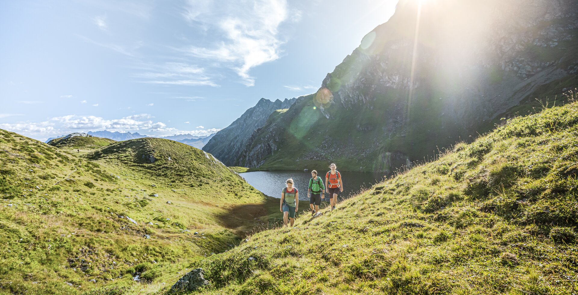 Wandern Seetal - Silvretta Montafon | © Silvretta Montafon - Stefan Kothner Drei Personen wandern bei Sonnenschein im Sommer in der Nähe eines Bergsees umringt von hohen Bergen. | © Silvretta Montafon - Stefan Kothner