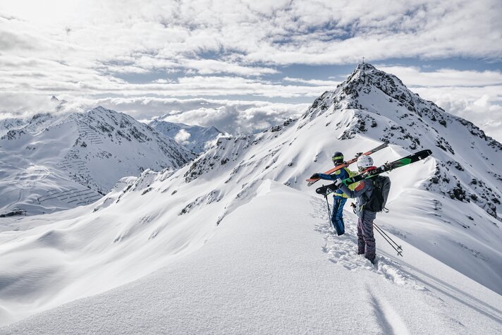 Zwei Skifahrer genießen die Aussicht auf die schneeverdeckten Berge vor dem Freeriden in der SIlvretta Montafon | © Silvretta Montafon - Michael Müller