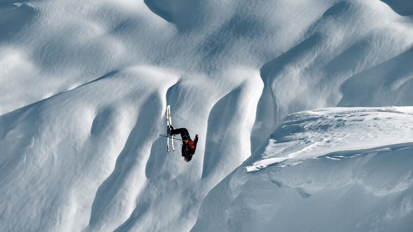 Ein Freerider macht einen Backflipp in den tief verschneiten Alpen. | © Silvretta Montafon - Mathäus Gartner