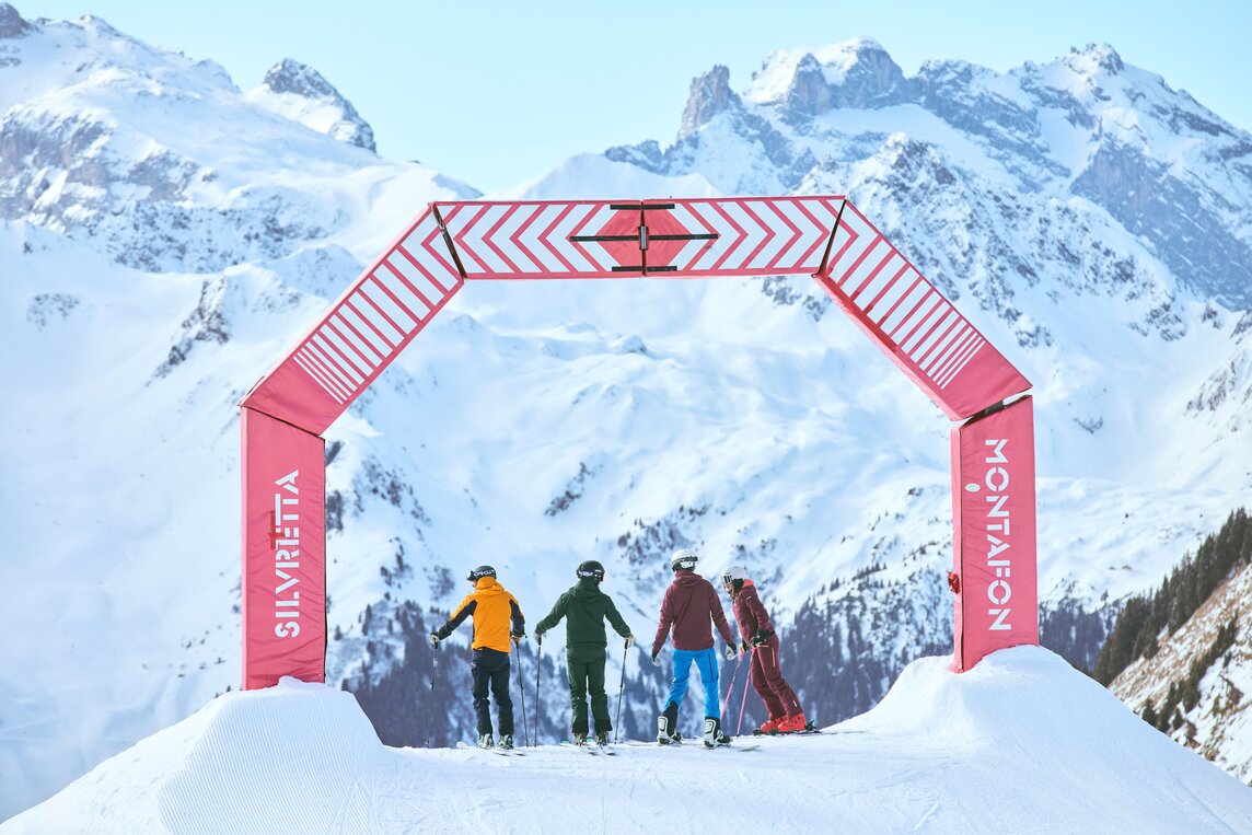 Eine Gruppe von drei Skifahrern und ein Snowboarder stehen auf der Piste zum Race Cross in der Silvretta Montafon. | © Silvretta Montafon - Stefan Kothner