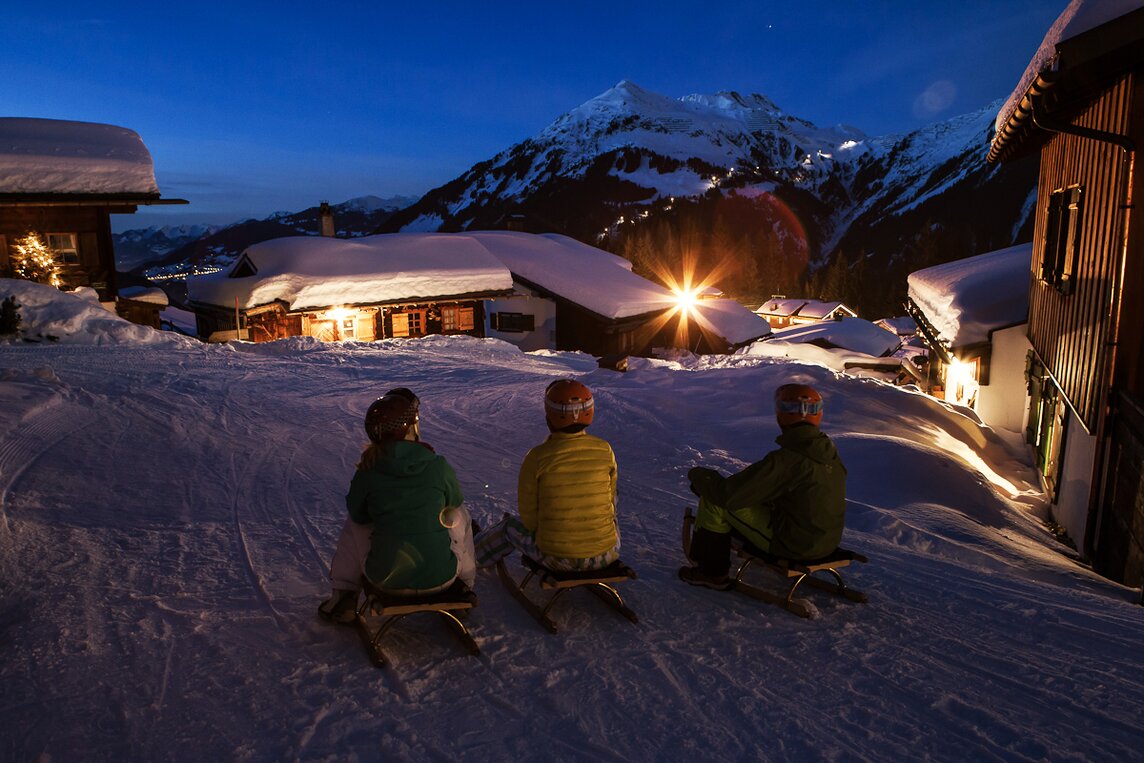Nachtrodeln - Silvretta Montafon | © Silvretta Montafon - Daniel Zangerl Drei Freunde auf dem Rodel vor der Abfahrt über die Nachtrodelbahn Garfrescha in der Silvretta Montafon | © Silvretta Montafon - Daniel Zangerl
