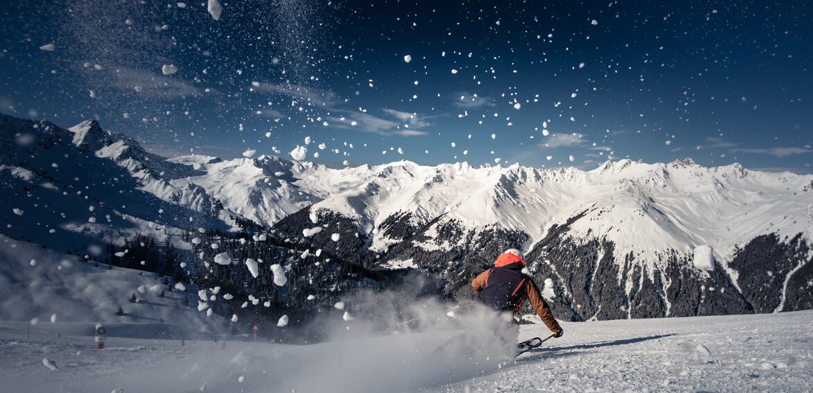 Skifahren - Silvretta Montafon | © Silvretta Montafon - Daniel Hug Ein Skifahrer auf der Piste und spritzender Schnee im Vordergrund. | © Silvretta Montafon - Daniel Hug