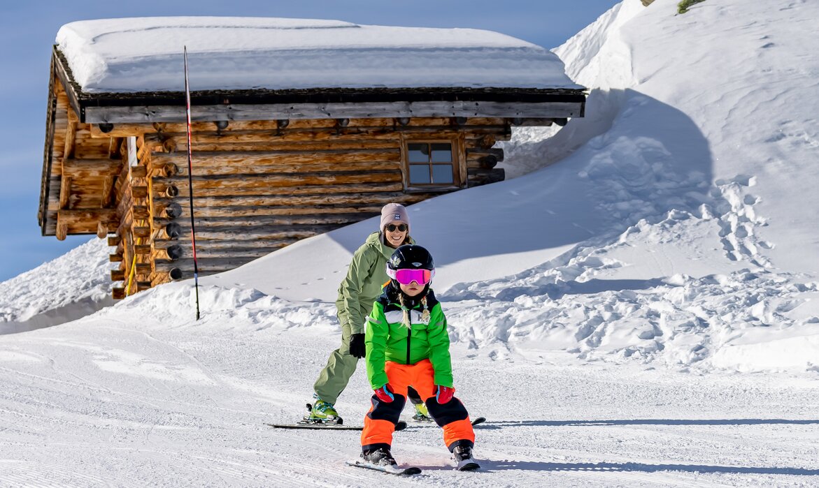 Ein Kind auf Ski übt mit ihrer Mutter den Pflug auf einer Anfängerpiste. | © Silvretta Montafon - Torsten Wenzler