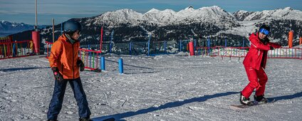 Ein Kind und ein Skilehrer beim Snowboardkurs in der Silvretta Montafon. | © Silvretta Montafon - Vanessa Strauch