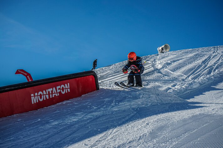 Ein Kind fährt auf einen Kicker im Snowpark während des Skikurses in der Silvretta Montafon. | © Silvretta Montafon - Vanessa Strauch