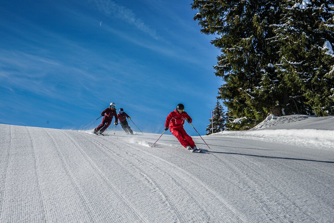 Ein Skilehrer fährt mit zwei Personen beim Privatkurs die Piste hinunter. | © Silvretta Montafon - Vanessa Strauch