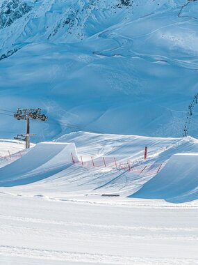 Zwei Kicker im Snowppark Montafon und die Hochalpila Bahn im Hintergrund. | © Silvretta Montafon - Matty Cox