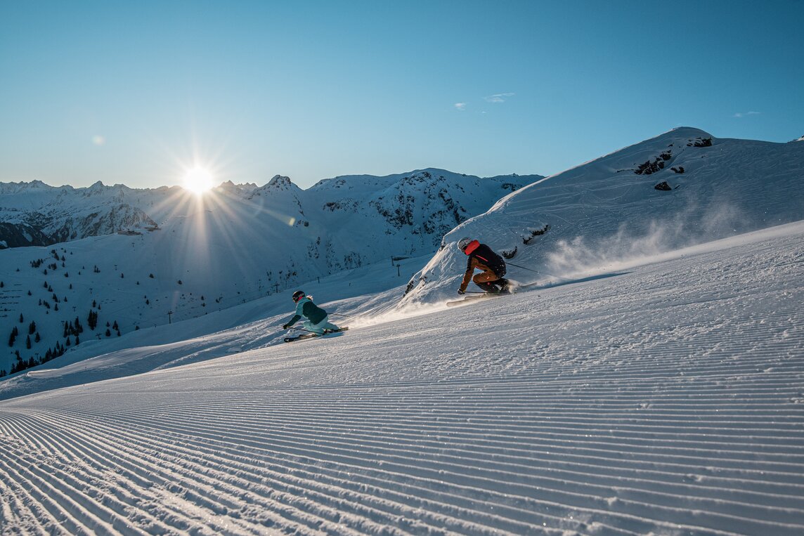 Zwei Skifahrer gleiten über die frisch präparierten Pisten bei Sonnenaufgang bei der Nova Exklusiv in der Silvretta Montafon | © Silvretta Montafon - Daniel Hug