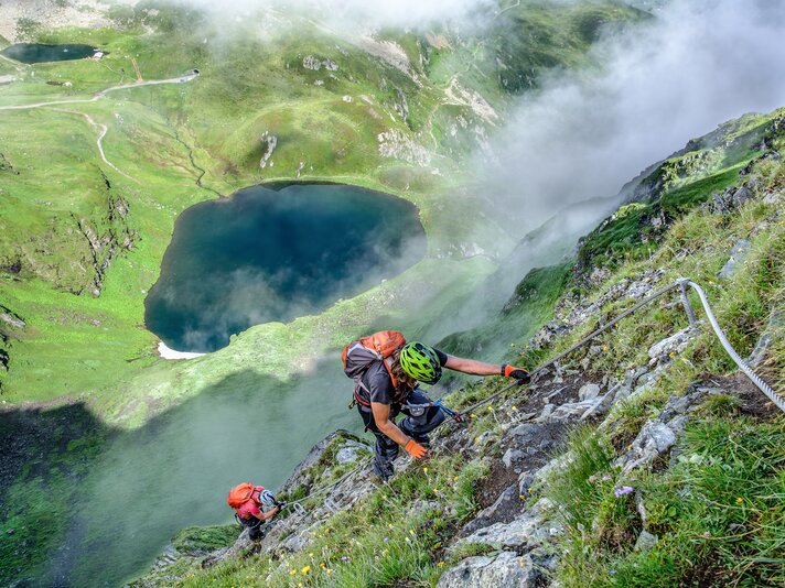 Zwei Personen im Klettersteig oberhalb eines Bergsees in der Silvretta Montafon. | © Silvretta Montafon - Bertram Waldner
