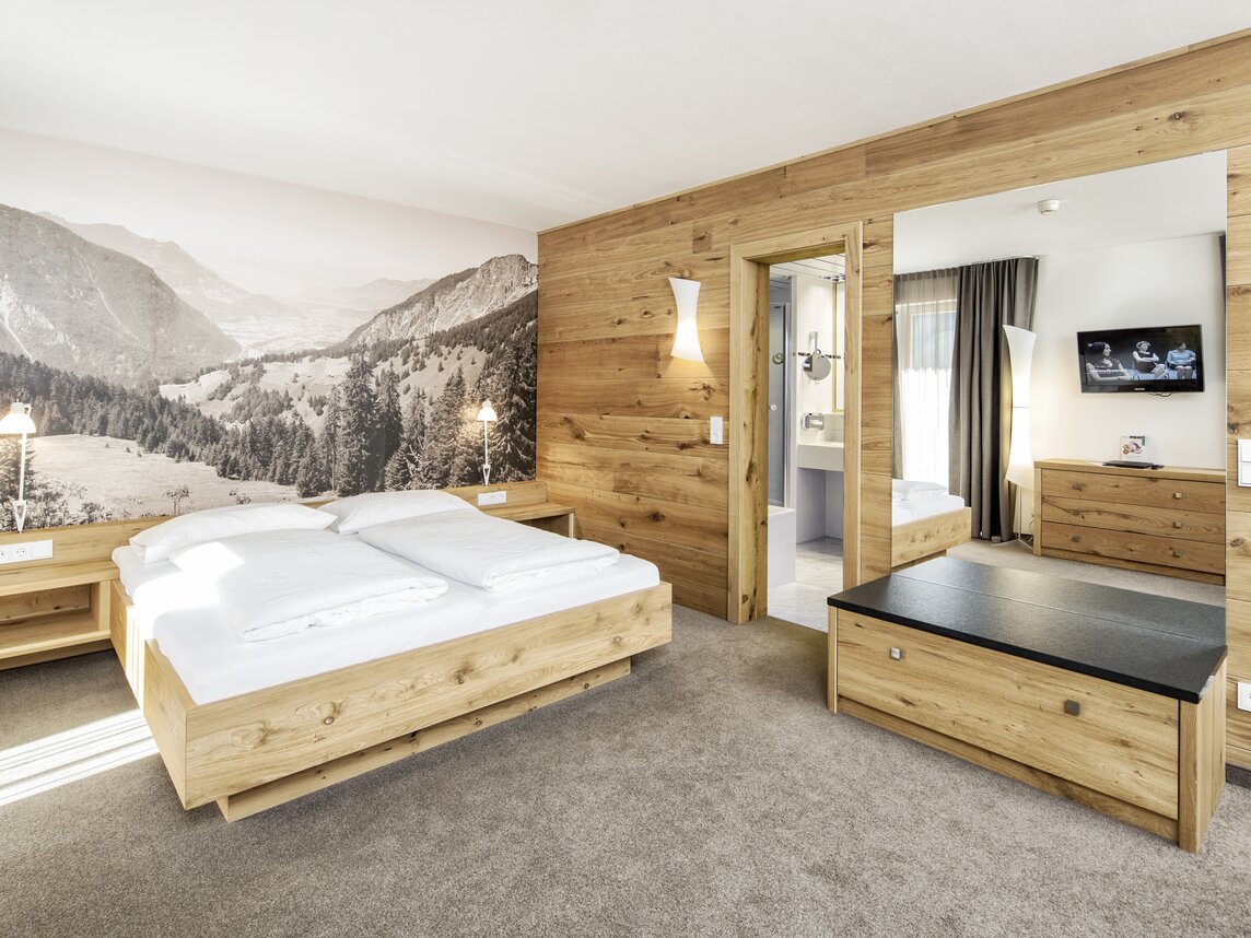 Gemütliches Doppelbett mit anliegendem Badezimmer | © Silvretta Montafon - Markus Gmeiner